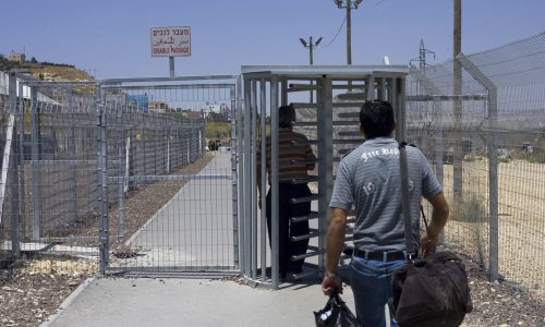 פועלים פלסטיניים עוברים במחסום לקראת כניסתם לישראל | צילום: Olivier Fitoussi /FLASH90